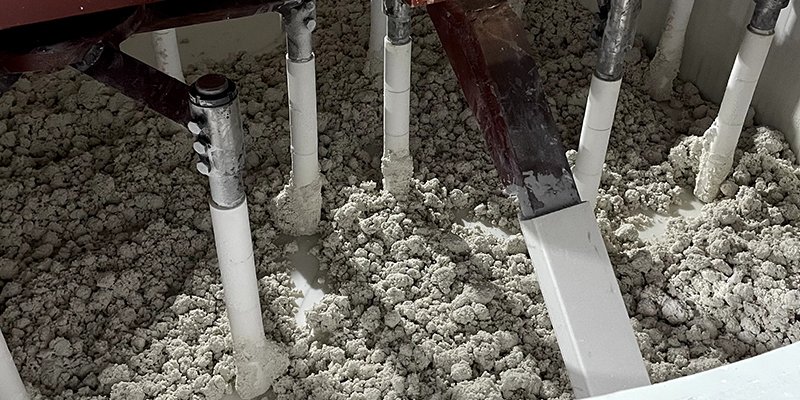 Quartz Material Mixing Process An industrial mixer combining quartz, resin, and pigments.