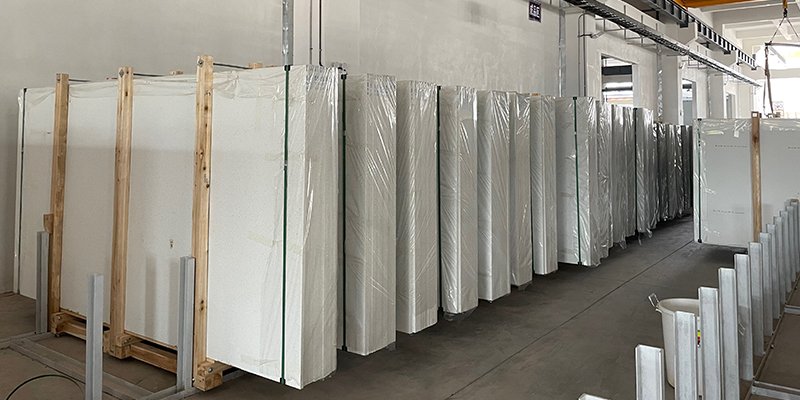 A factory floor with stacks of polished quartz slabs ready for export.