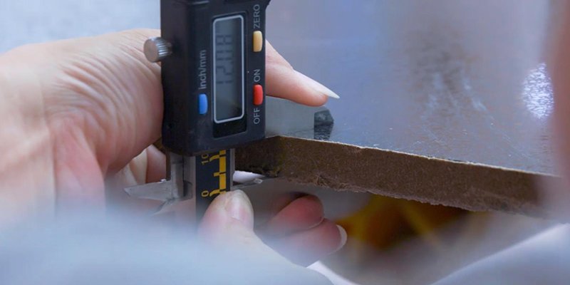 Measuring quartz slab thickness a person using a vernier caliper to measure the thickness of a quartz slab